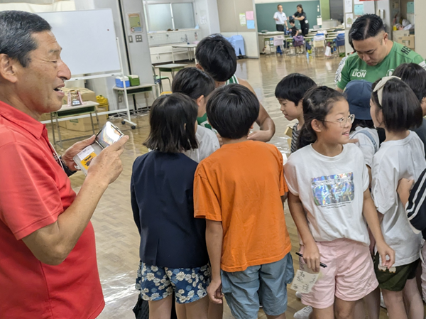 給食後の交流。選手たちは児童にサインをもとめられ大騒ぎ