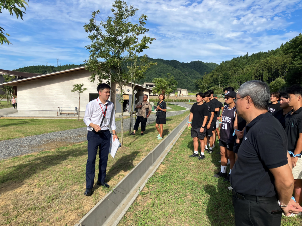 震災遺構大川小学校で説明を受けるファングスメンバー