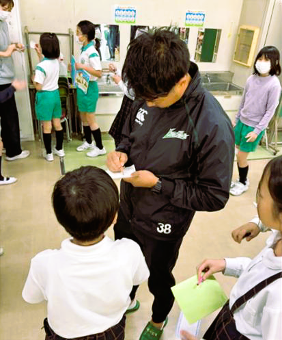 給食後の交流。 選手はサイン攻めに